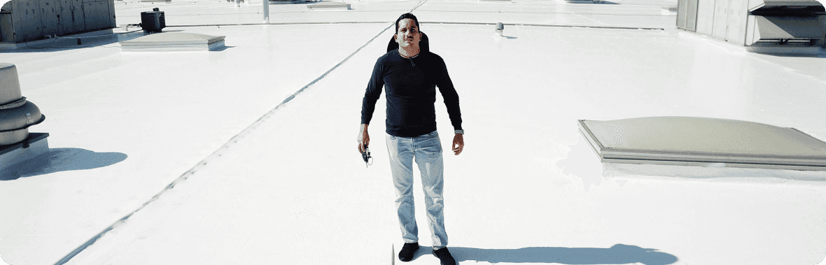 Francisco “Pancho” Serrano standing on a white commercial membrane roof