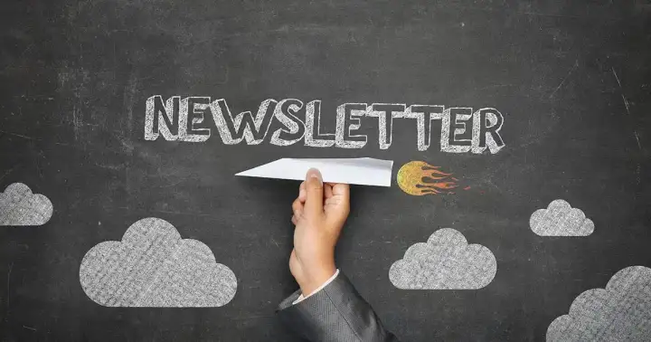 Newsletter open on a screen next to a coffee cup