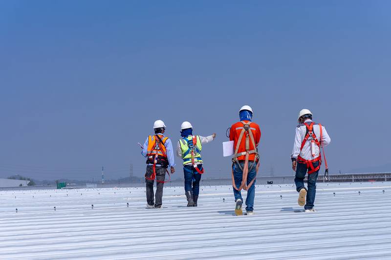Commercial roofing crew working on a flat industrial rooftop