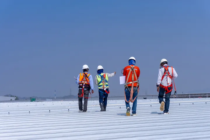 Commercial roofing crew working on a flat industrial rooftop