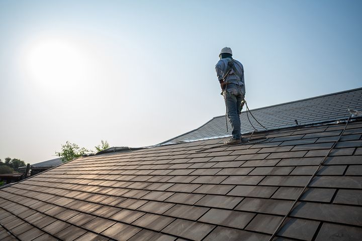 Roofer working on the shingles of a residential roof